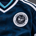 Newcastle United 2026/27 Away Kids Kit — sewn crest and fabric detail; AI-assisted visualization of supplier-verified kit